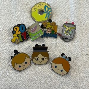 Assorted tinkerbell pins and Wendy, John, and Michael tsum tsum trading pins